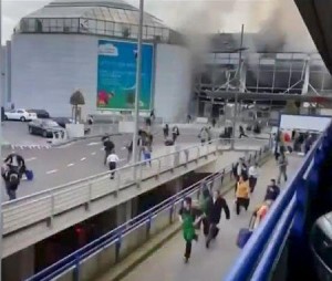 People flee from the Brussels airport in this image taken from video, shot by a bystander in the the immediate aftermath of blasts at the airport near Brussels, Belgium, March 22, 2016.  REUTERS/Asher Gunsberg/Handout via Reuters TV