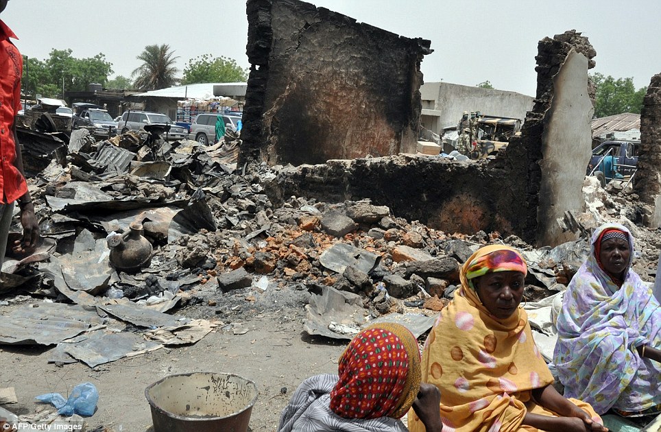 Women sit at Gamboru central market in northeastern Nigeria on Monday, burnt by suspected Boko Haram insurgents during  a previous attack.