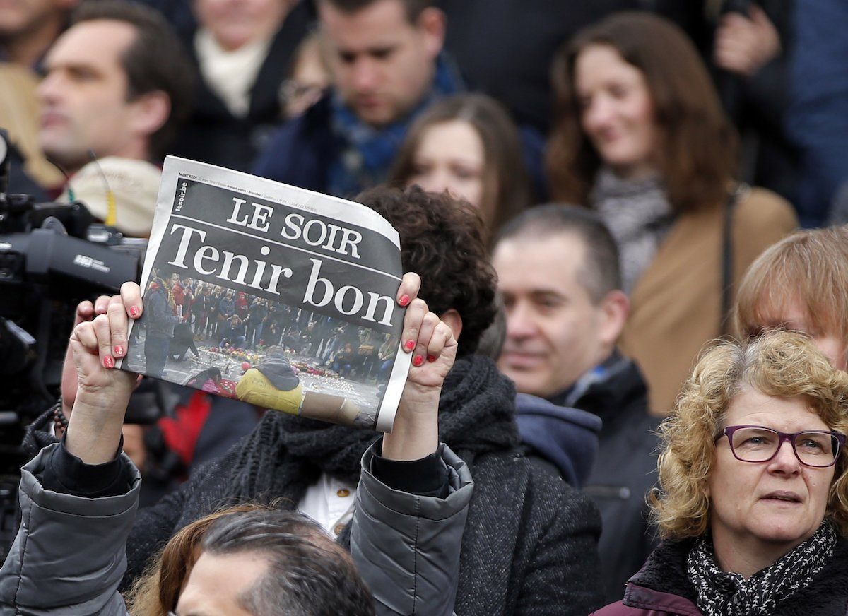A newspaper with the headline "Hold Fast!" is held up following a minute silence for victims of Tuesday's bomb attacks in Brussels, Belgium, March 23, 2016.