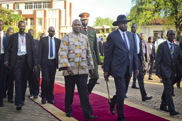 South Sudan's new Vice President Riek Machar, center-left, walked with President Salva Kiir, center-right, after being sworn in at the presidential palace in Juba.