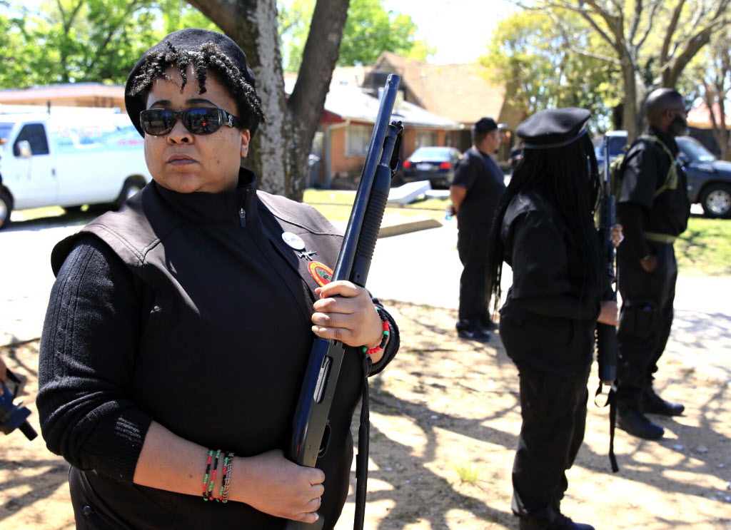 Krystal Muhammad with a shot gun and other members of the New Black Panther Party stand guard across the Muhammad Mosque in Dallas, Saturday, April 2, 2016. (Jae S. Lee/The Dallas Morning News)