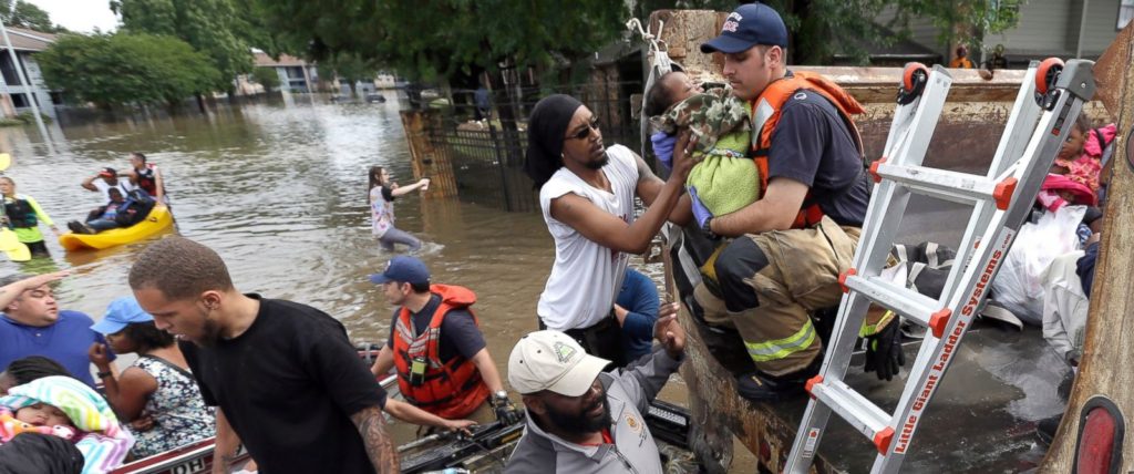 Residents are helped into a dump truck as they evacuate their apartment complex.