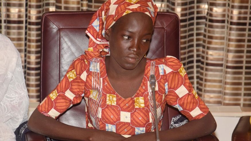 Amina Ali, the rescue Chibok school girl, sits during a meeting with Nigeria's President Muhammadu Buhari at the Presidential palace in Abuja, Nigeria, Thursday, May. 19, 2016. The first Chibok teenager to escape from Boko Haram's Sambisa Forest stronghold was flown to Abuja on Thursday and met with Nigeria's president, even as her freedom adds pressure on the government to do more to rescue 218 other missing girls. (AP Photo/Azeez Akunleyan) 