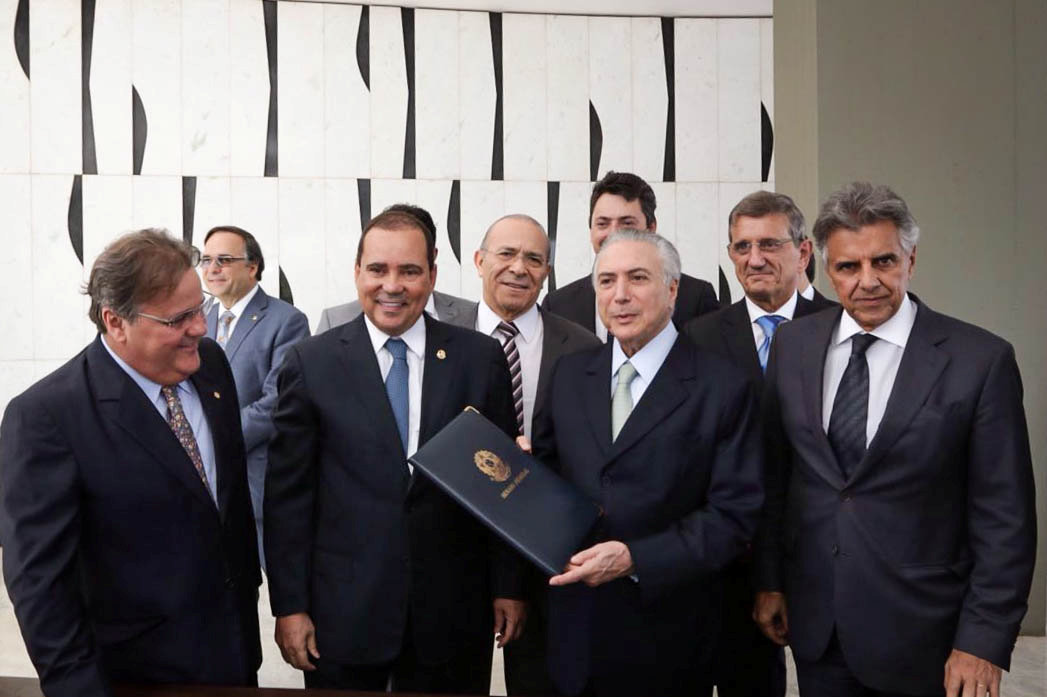 Brazil's Vice President Michel Temer (3rd R) holds a folder with a document notifying him of becoming the interim president after the Brazilian Senate voted to impeach President Dilma Rousseff, at his Jaburu Palace official residence in Brasilia, Brasil, May 12, 2016. Marcos Correa/Courtesy of Brazil's Vice Presidency/Handout via.
