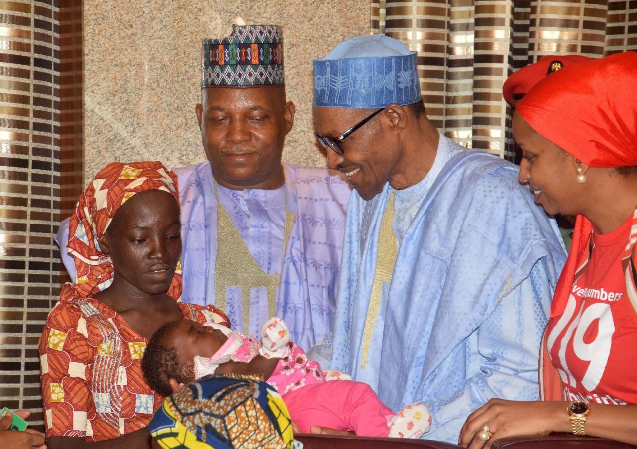 Nigeria President Muhammadu Buhari, second right, receives Amina Ali, the rescued Chibok school girl, at the Presidential palace in Abuja, Nigeria, Thursday, May. 19, 2016. The first Chibok teenager to escape from Boko Haram's Sambisa Forest stronghold was flown to Abuja on Thursday and met with Nigeria's president, even as her freedom adds pressure on the government to do more to rescue 218 other missing girls. (AP Photo/Azeez Akunleyan)