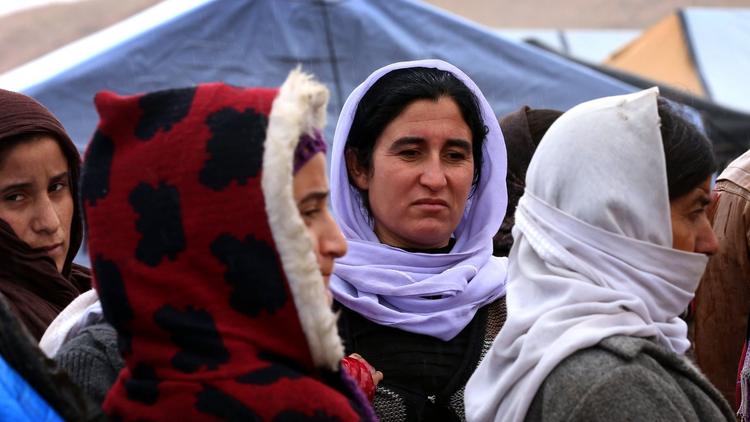 Displaced Iraqi women from the Yazidi community, who fled violence between Islamic State jihadists and Peshmerga fighters in the northern Iraqi town of Sinjar, gathering around their tents at a refugee camp set up on Mount Sinjar in Jan. 2015.  (Safin Hamed / AFP/Getty Images)