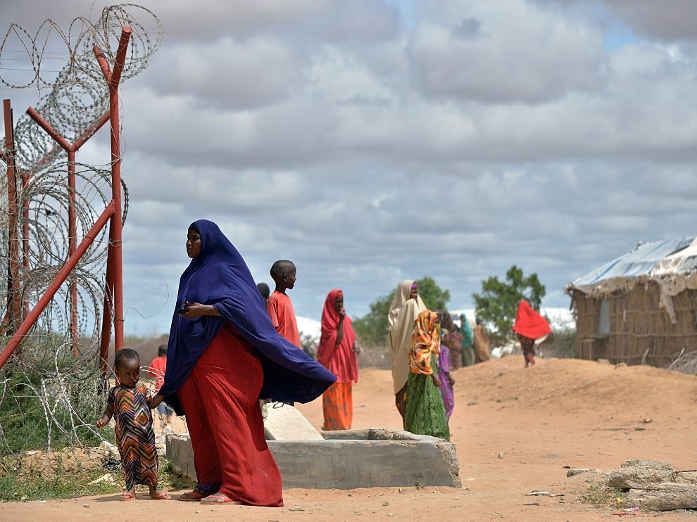 A refugee stands with her son just outside a fenced perimeter at the sprawling Dadaab refugee camp in May 2015. 