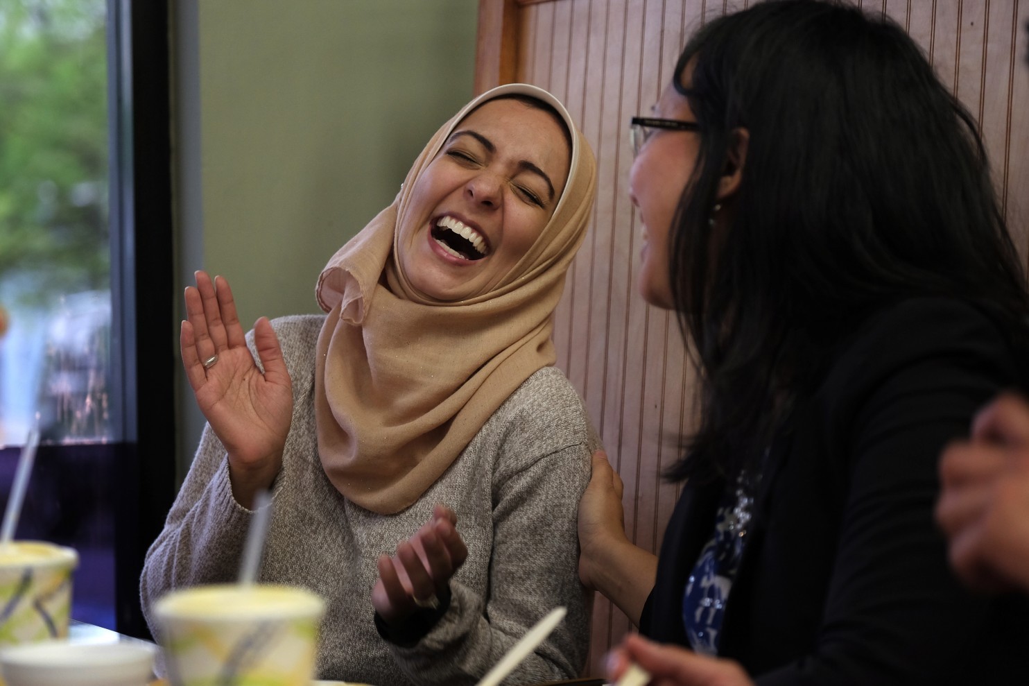 Rida Bukhari-Rizvi, left, jokes with Nadia Syahmalina during a gathering of the Muslim Democratic Club of Montgomery County. (Bonnie Jo Mount/The Washington Post)