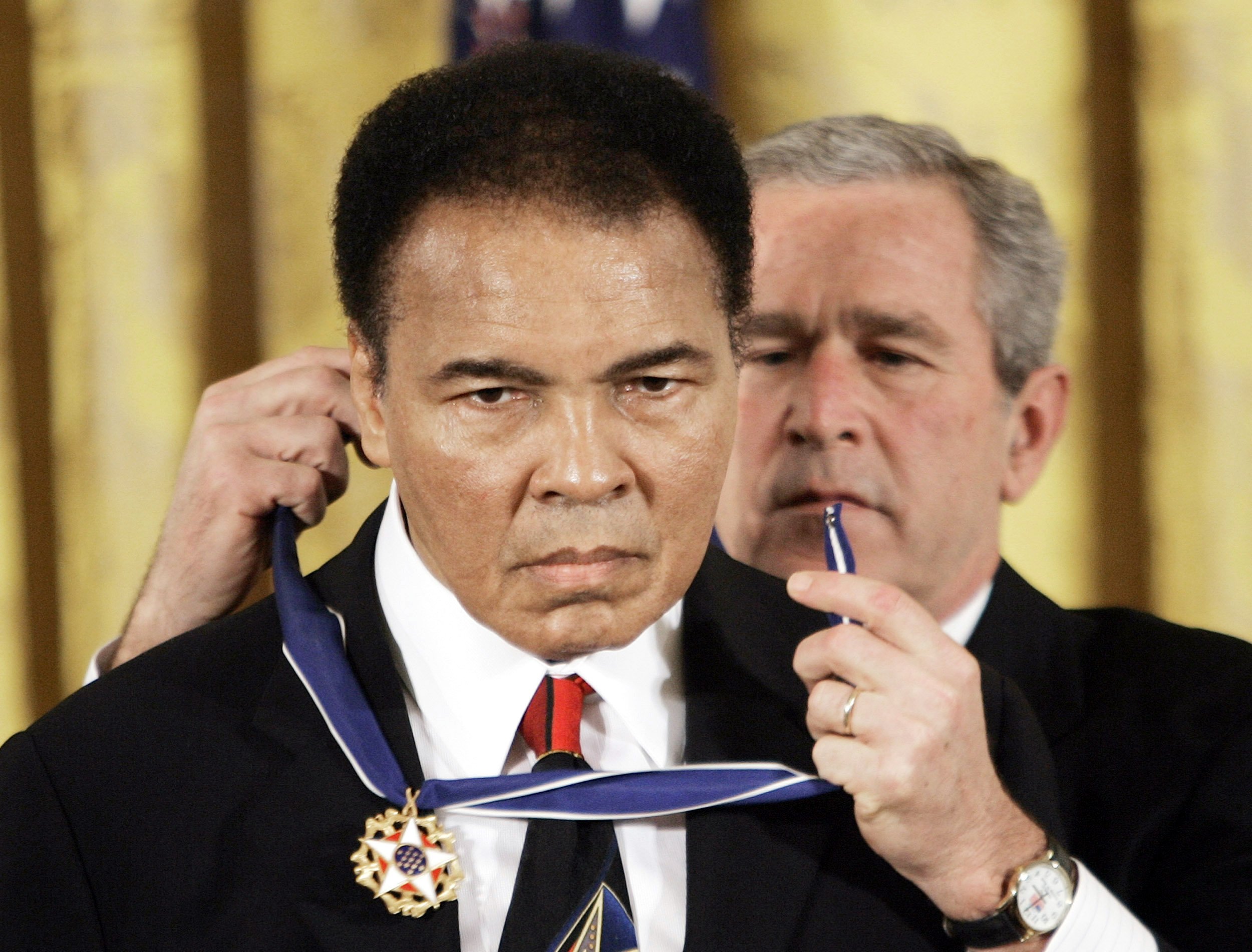 FILE - In this Nov. 9, 2005 file photo, President Bush presents the Presidential Medal of Freedom to boxer Muhammad Ali in the East Room of the White House. He is now so much a part of the nation's social fabric that it's hard to comprehend a time when Ali was more reviled than revered.   (AP Photo/Evan Vucci, File)