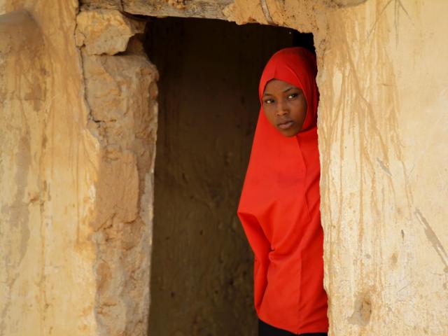 A girl peers out of a doorway at a local Islamic school in Zaria, Kaduna state, Nigeria, February 2, 2016