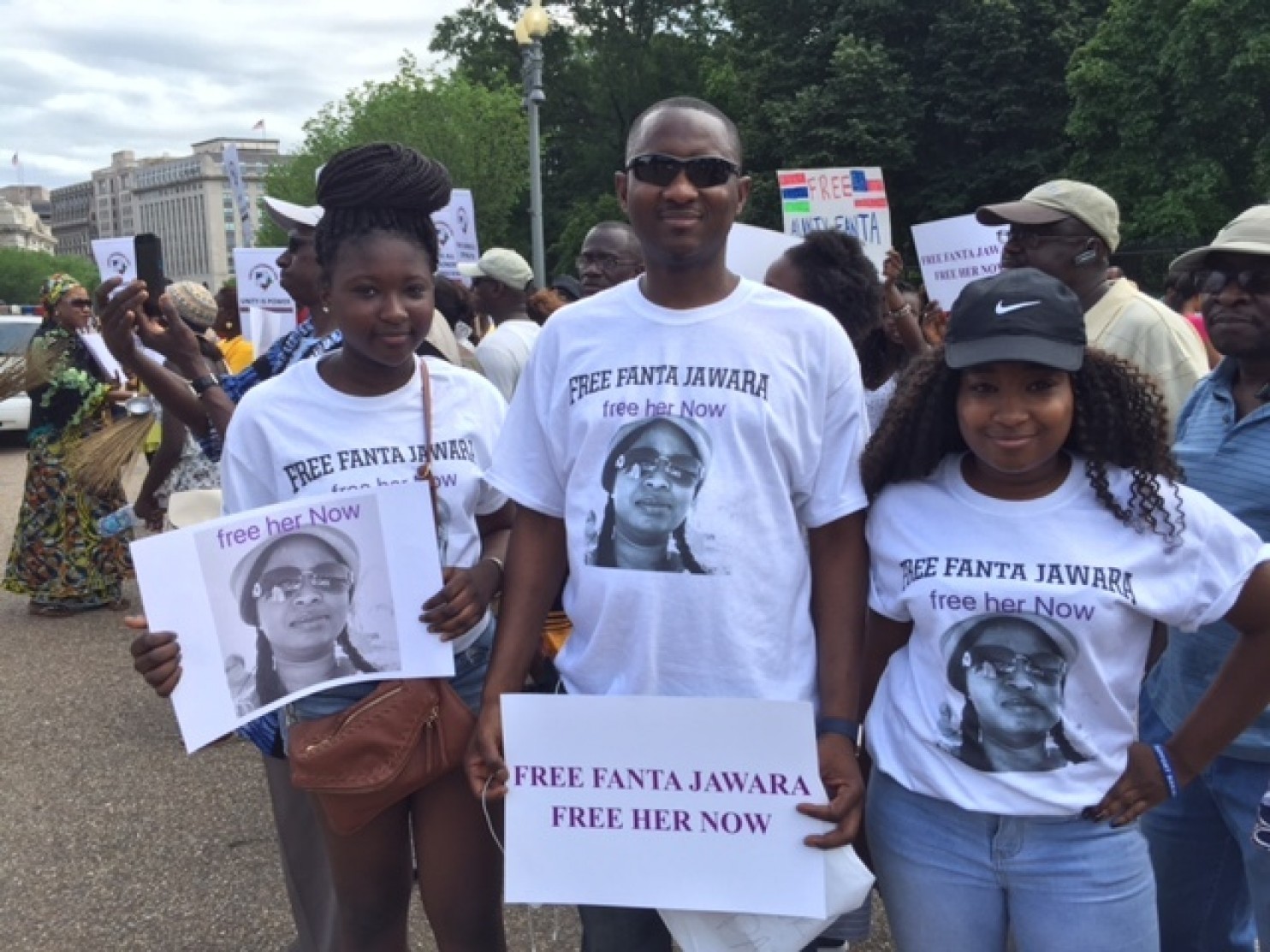 Ebrima Jawara, a mechanic at Ourisman Honda in Bethesda, and his daughters Sarah Jawara, 12, left, and Aminata Jawara protest outside the White House. Their mother has been held for almost two months in a prison in Gambia. (Family Photo) 