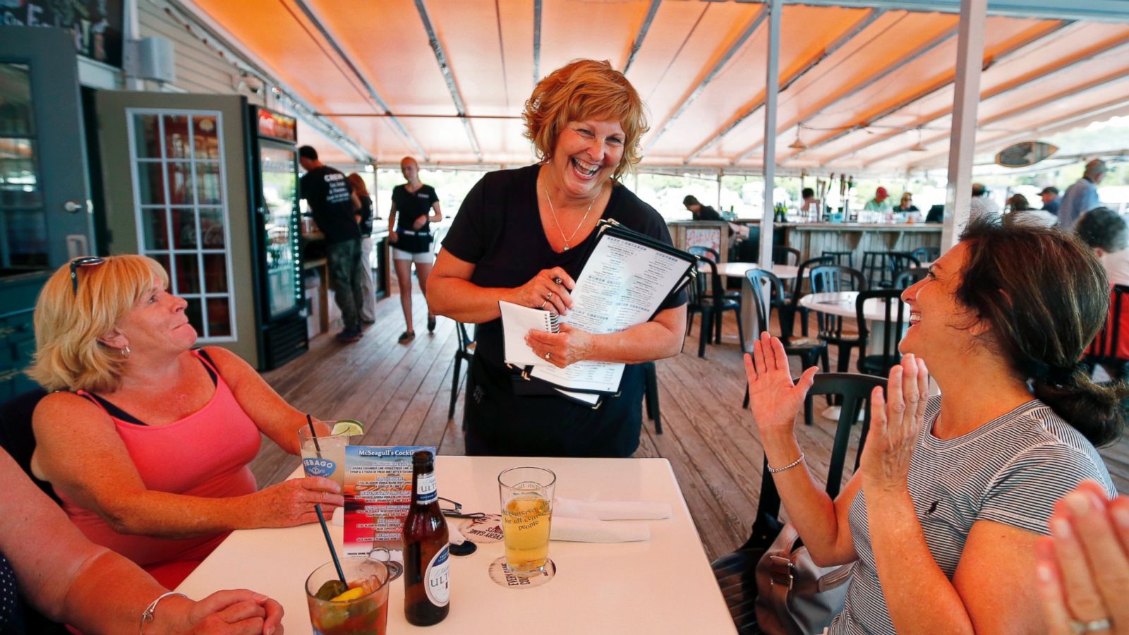 Ann LePage chats with diners after taking their order at McSeagull's restaurant, Thursday, June 23, 2016, in Boothbay Harbor. The wife of America's lowest paid governor has taken on a summer waitressing job near her and husband's Boothbay home, and she's saving up for a car. (AP Photo/Robert F. Bukaty)
