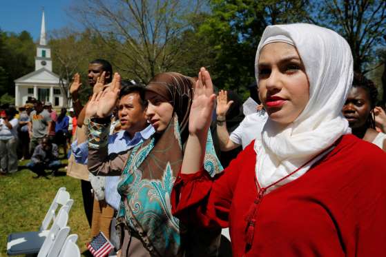Hala Alhallaq of Iraq takes the oath of citizenship as she and 145 others become United States citizens during a naturalization ceremony at Old Sturbridge Village in Sturbridge, Massachusetts.