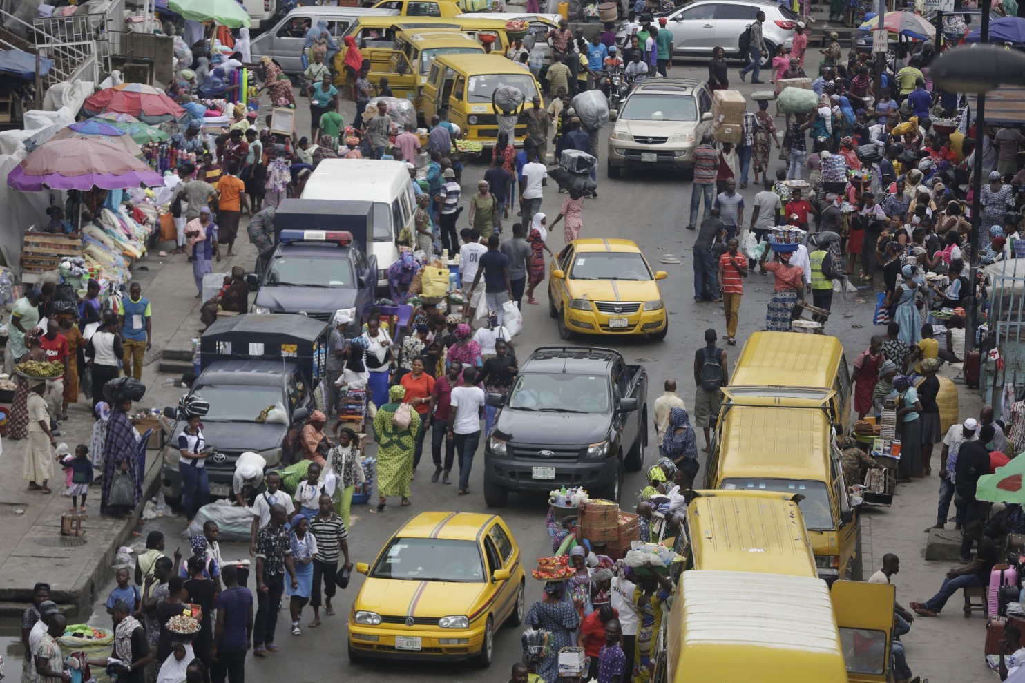 In this photo taken Monday June 20, 2016, pedestrians shop at a market in Lagos, Nigeria. Officials in Nigeria’s biggest city are closing down dozens of churches, mosques and nightclubs in a bid to reduce noise in Lagos, the seaside commercial center where honking horns and thrumming generators compete with lusty hymn-singing and loudspeakers calling people to prayer. (Sunday Alamba/Associated Press) 