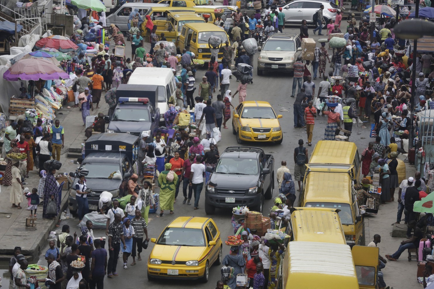 In this photo taken Monday June 20, 2016, pedestrians shop at a market in Lagos, Nigeria. Officials in Nigeria’s biggest city are closing down dozens of churches, mosques and nightclubs in a bid to reduce noise in Lagos, the seaside commercial center where honking horns and thrumming generators compete with lusty hymn-singing and loudspeakers calling people to prayer. (Sunday Alamba/Associated Press)
