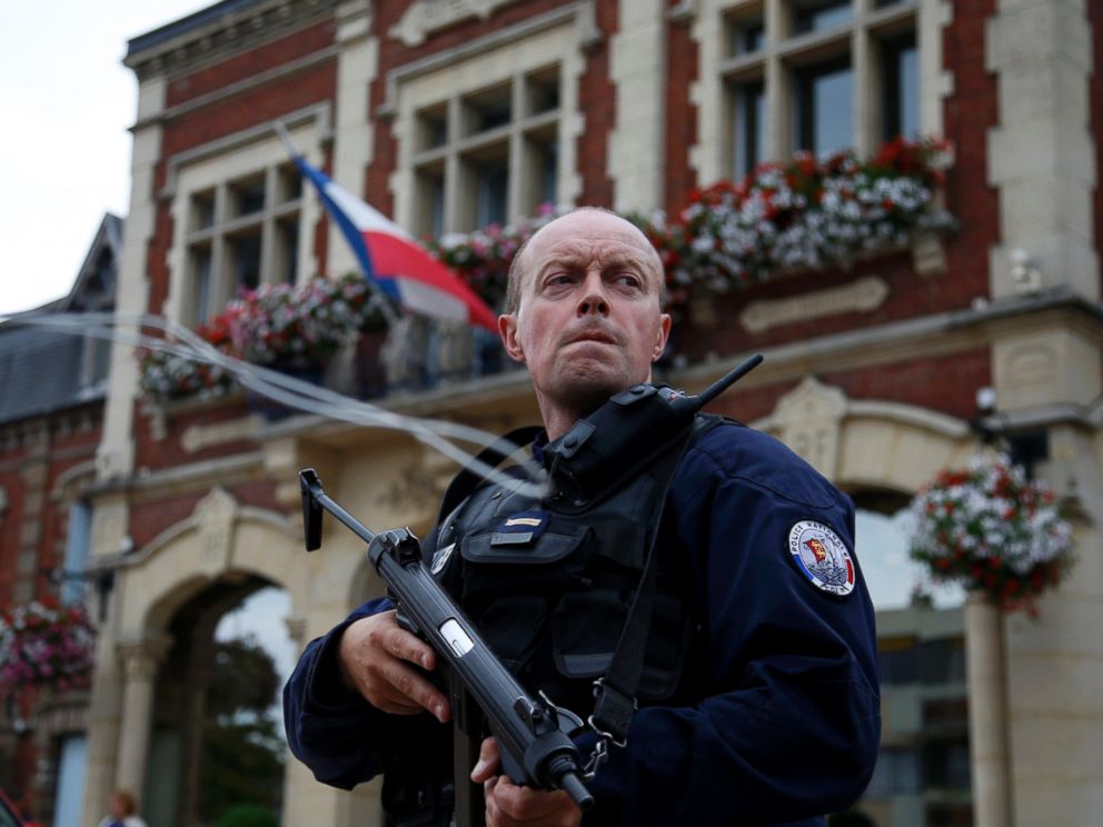 A policeman secures a position in front of the city hall after two assailants had taken five people hostage in the church at Saint-Etienne-du-Rouvray near Rouen in Normandy, France, July 26, 2016. 