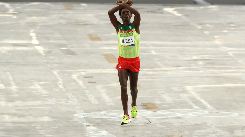 Feyisa Lilesa of Ethiopia celebrates crosses the line to win silver during the men's marathon.