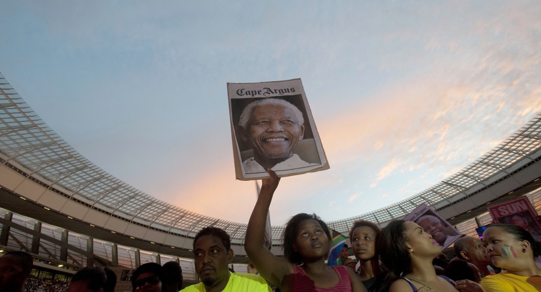 A woman holds up a poster with a photo of Nelson Mandela , during the Nelson Mandela tribute concert, called, " A life celebrated", at Cape Town Stadium on December 11 2013, in Cape Town. Mandela, South Africa's first democratically elected president, and Nobel Peace Prize winner, died at his home in Johannesburg on December 5, 2013. AFP / RODGER BOSCH (Photo credit should read RODGER BOSCH/AFP/Getty Images)