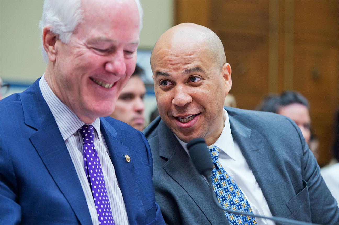 File: Sen. Johnson Cornyn, R-Texas, left, talks with Sen. Cory Booker, D-N.J., during a House Oversight and Government Reform Committee hearing on criminal justice reform, July 14, 2015. This week Members of Congress, led by Senator John Cornyn (R-TX) and Senator Cory Booker (D-NJ) in the Senate, and Congressman Sam Johnson (R-TX) and Congressman John Yarmuth (D-KY) in the House of Representatives, introduced a resolution acknowledging the broad benefits of Family Service Learning. 