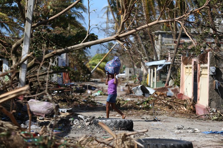 A woman in Gelée, Haiti, on Friday navigated the rubble after Hurricane Matthew. Some reports put the death toll at 800. Credit Orlando Barría/European Pressphoto Agency 