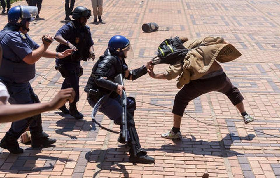 A policeman clashes with a student on the University of the Witwatersrand campus in Johannesburg, South Africa, on Monday, Oct. 10, 2016. Tear gas and water cannon were fired as hundreds of students protested at the university amid a bitter national dispute with university managers and the government over demonstrators' demands for free education.  Yeshiel Panchia  - AP Photo 