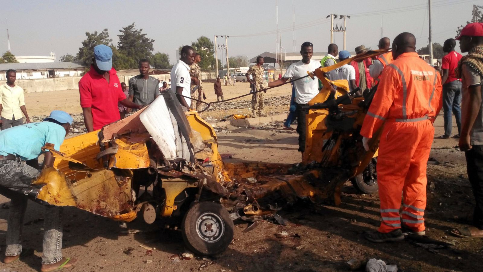 FILE- In this Saturday, Oct. 29, 2016 file photo, People clear debris after an explosion in Maiduguri, Nigeria. Nigeria's army says two women suicide bombers blew themselves up Friday morning Dec. 9, 2016, at a market in northeast Nigeria's Madagali town, killing at least 30 people and wounding dozens of others. (AP Photo/Jossy Ola, FILE)